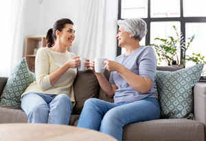 elderly mother and daughter having coffee