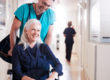 in home caregiver assisting a client out of hospital by wheelchair